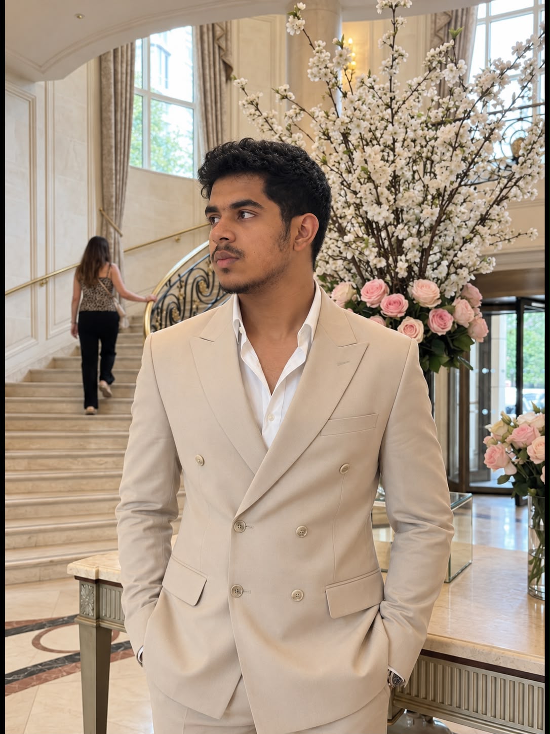 Omar Imran wearing a light suit in a bright interior.